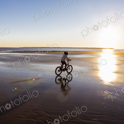 A boy riding a bicycle on the beach,St. Simon's Island, Georgia A boy riding a bicycle on the beach,St. Simon's Island, Georgia