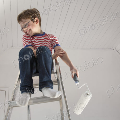 A boy seated on a stepladder.