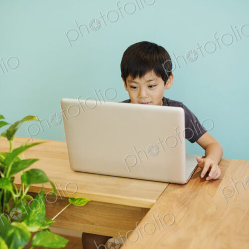 A boy using a computer in a classroom. A boy using a computer in a classroom.