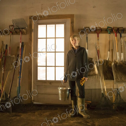 A boy with a feed bucket in the stables feedroom or toolshed of an animal sanctuary.… A boy with a feed bucket in the stables feedroom or toolshed of an animal sanctuary.…
