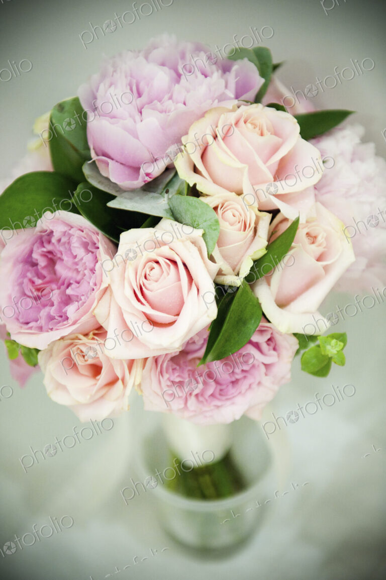 A bridal bouquet of pastel coloured pink roses, and pale lavender peonies with small…
