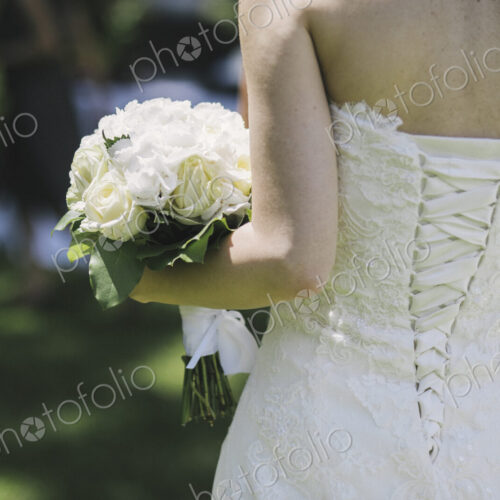 A bride in a fitted bodice, white dress with lacings across the fitted back panels. A bride in a fitted bodice, white dress with lacings across the fitted back panels.