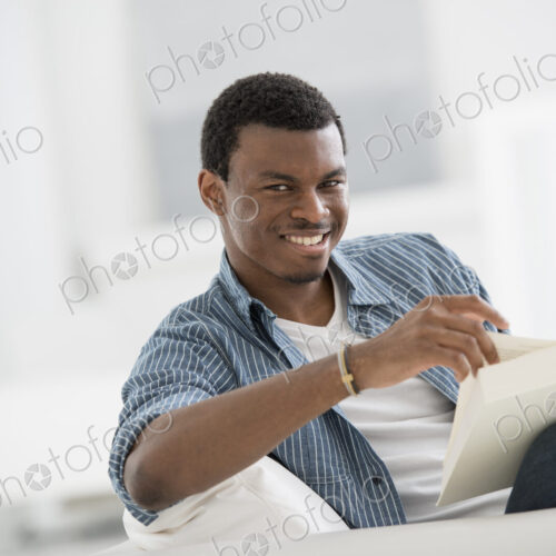 A bright white room interior. A man sitting reading a book. A bright white room interior. A man sitting reading a book.
