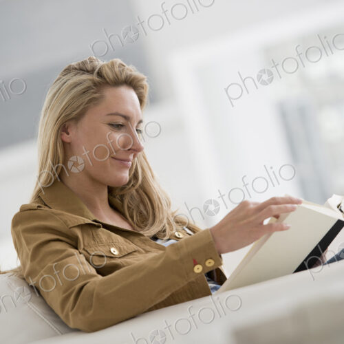 A bright white room interior. A woman sitting reading a book. A bright white room interior. A woman sitting reading a book.