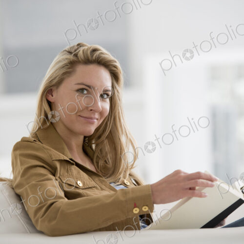 A bright white room interior. A woman sitting reading a book. A bright white room interior. A woman sitting reading a book.