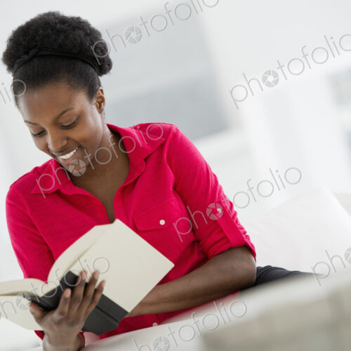 A bright white room interior. A woman sitting reading a book. A bright white room interior. A woman sitting reading a book.