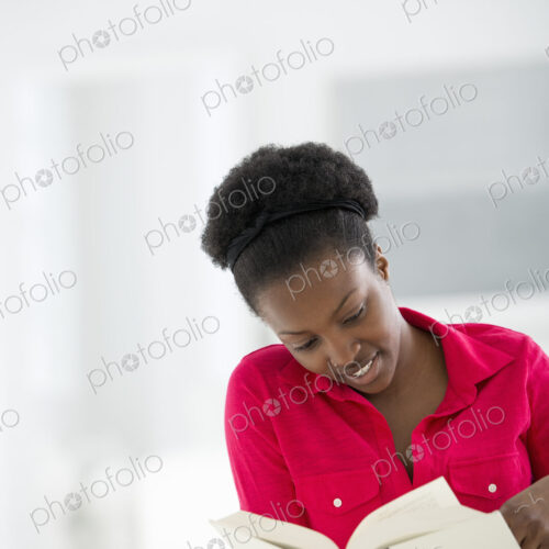 A bright white room interior. A woman sitting reading a book. A bright white room interior. A woman sitting reading a book.