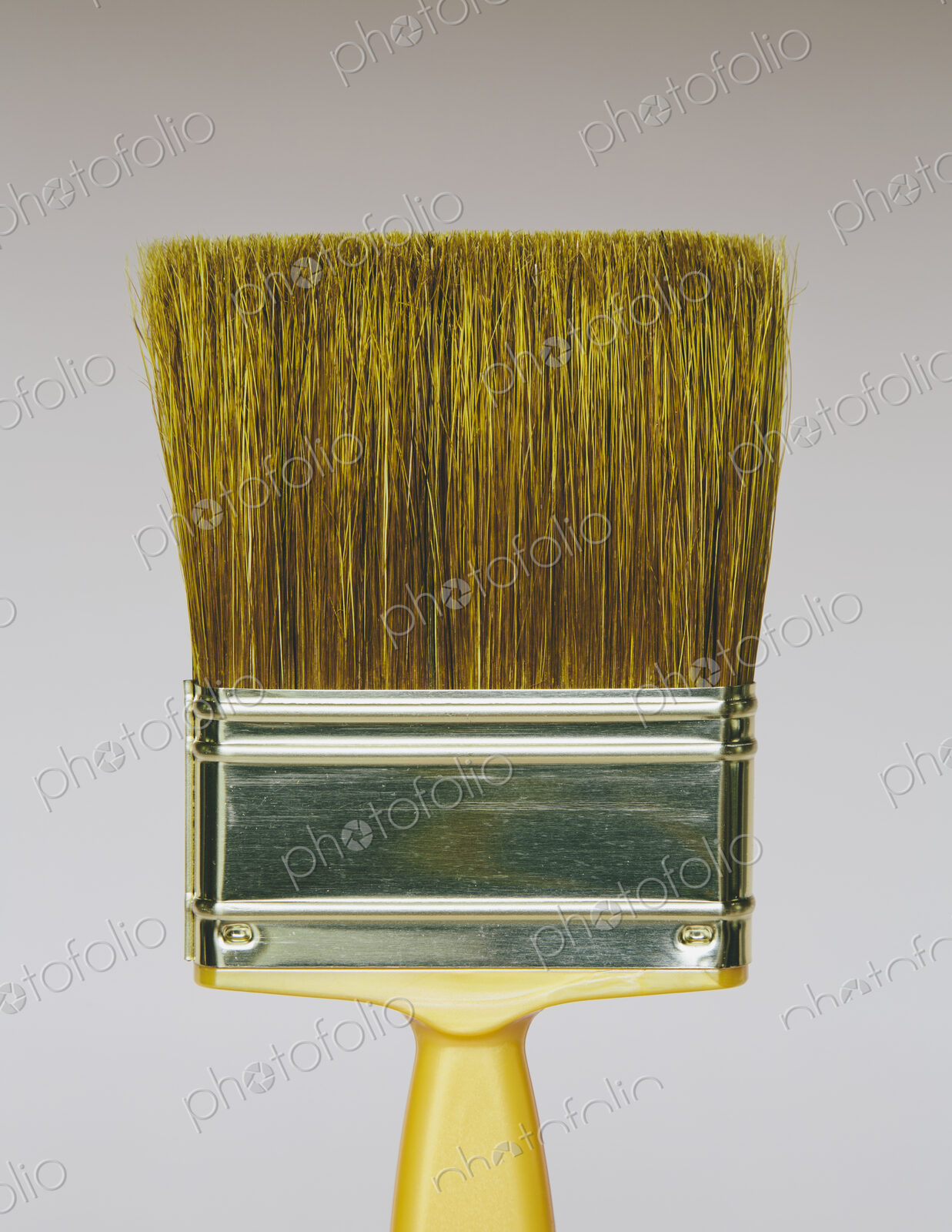 A bristle paintbrush with a yellow handle.