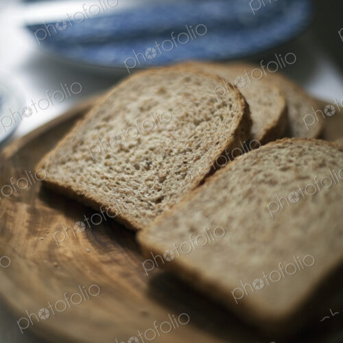 A buffet meal laid out. Sliced brown bread. A blue pate and knife. A buffet meal laid out. Sliced brown bread. A blue pate and knife.