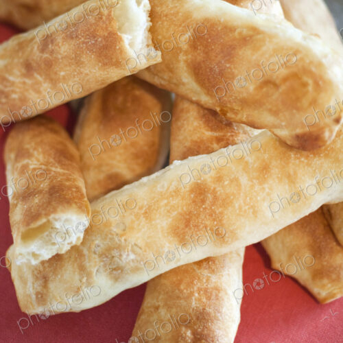 A buffet table laid out for a party. Organic food. Fresh bread, breadsticks.