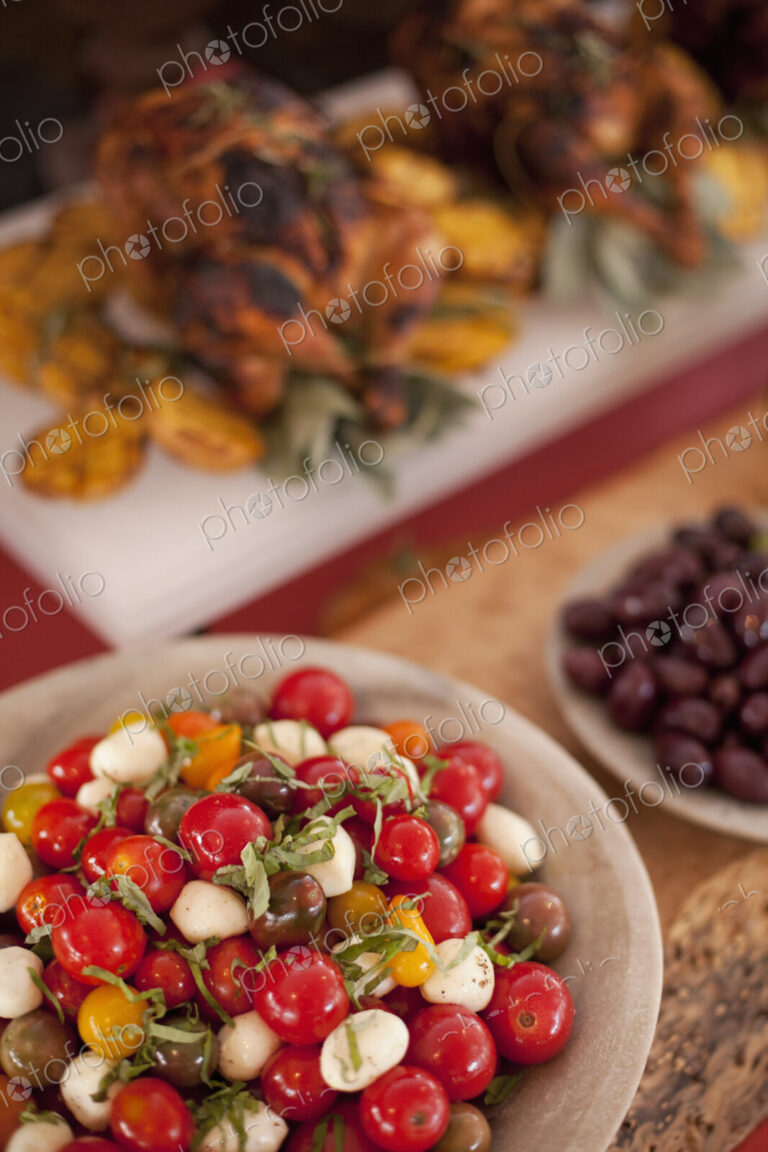 A buffet table laid out for a party. Organic food. Salads and a chicken dish.