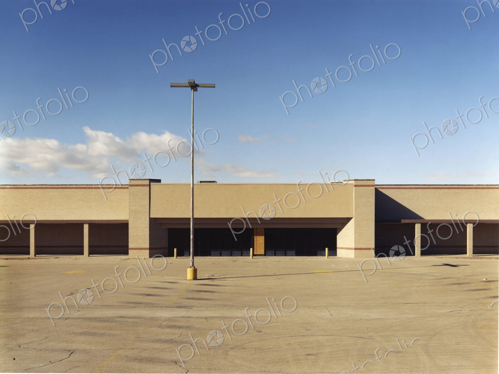 A building exterior, a single storey building with a large forecourt, carpark.