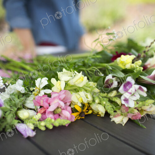 A bunch of summer garden flowers on an outdoor table.