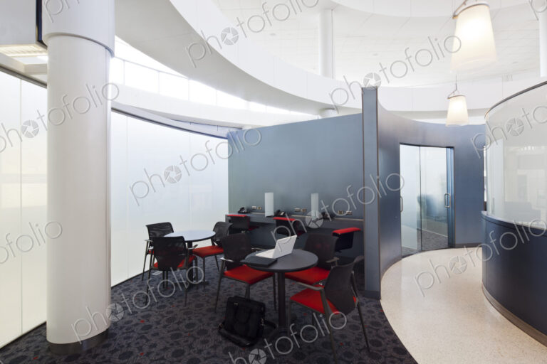 A business centre, tables and chairs, laptops and telephones.