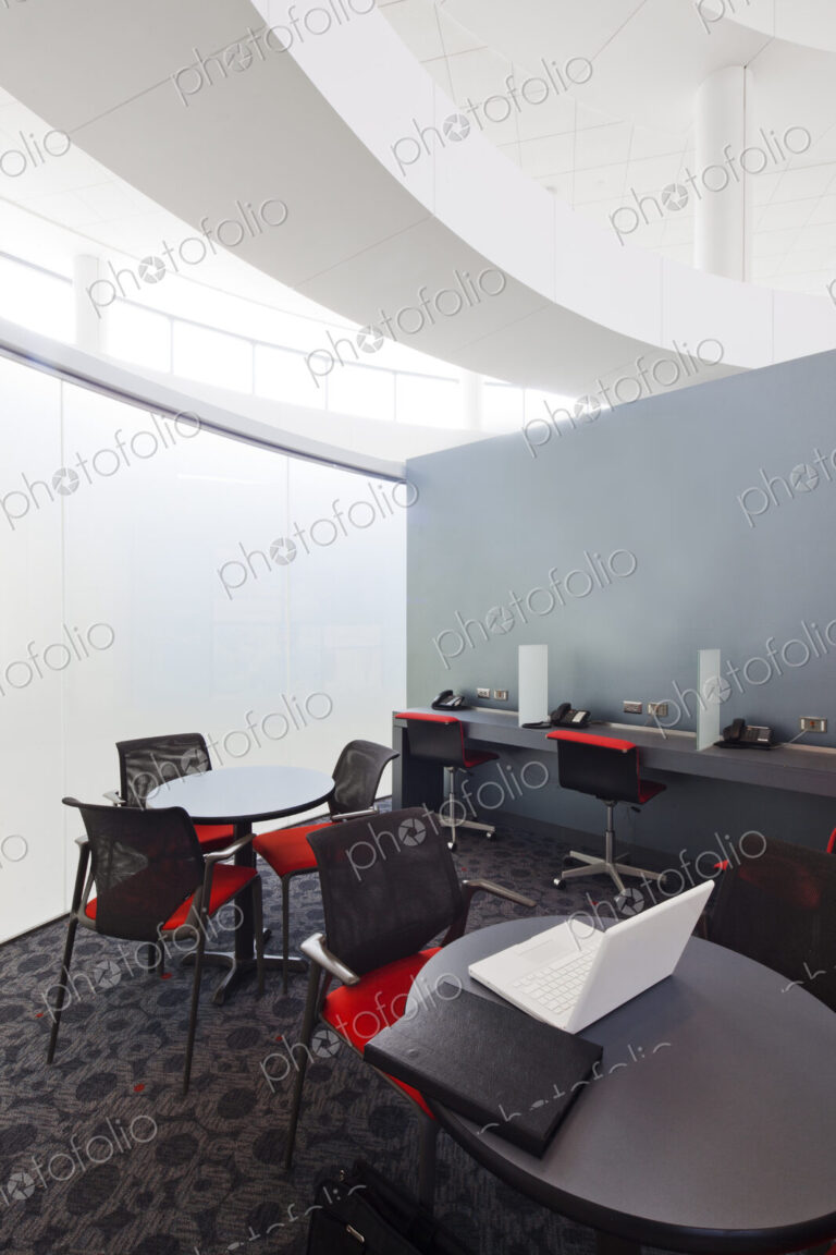 A business centre, tables and chairs, laptops and telephones.