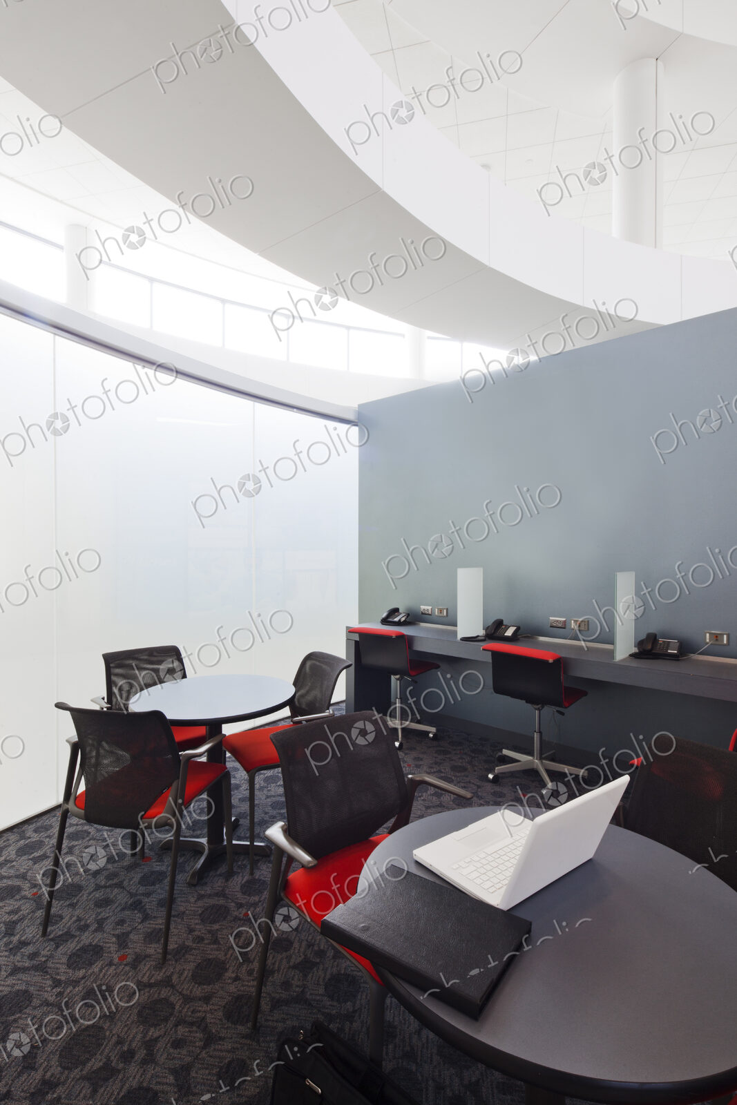A business centre, tables and chairs, laptops and telephones.