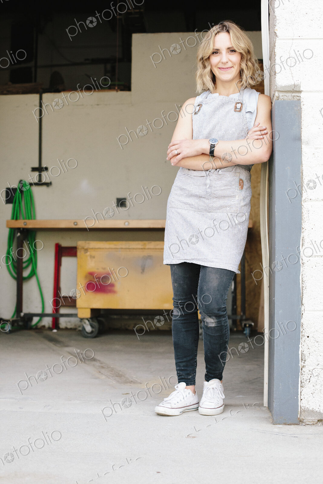A business owner and craftsman standing in the doorway of her workshop.