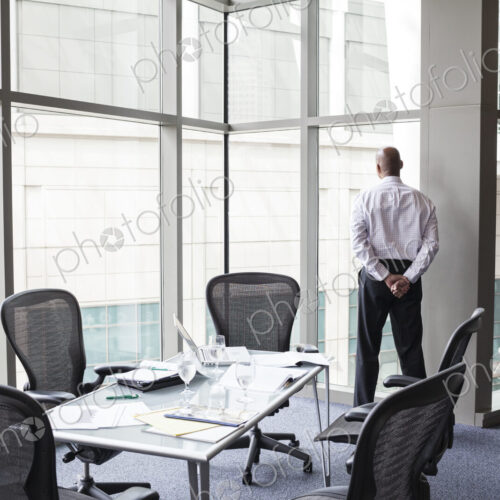 A businessman at a convention center window looking out of the window