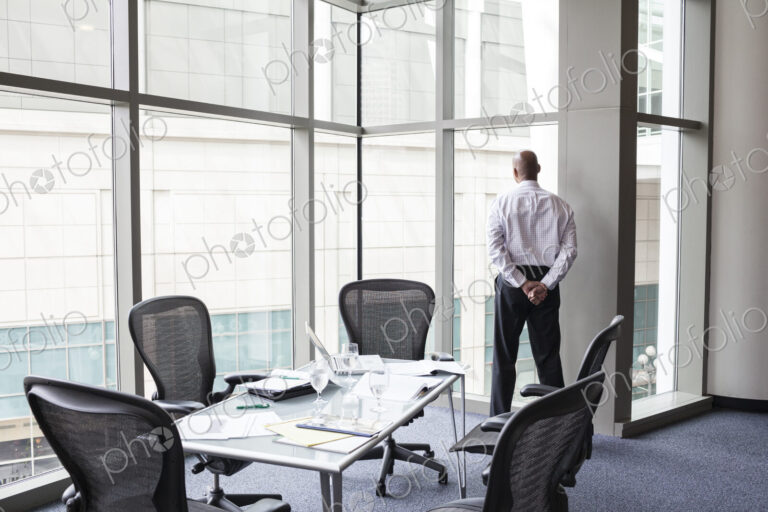 A businessman at a convention center window looking out of the window
