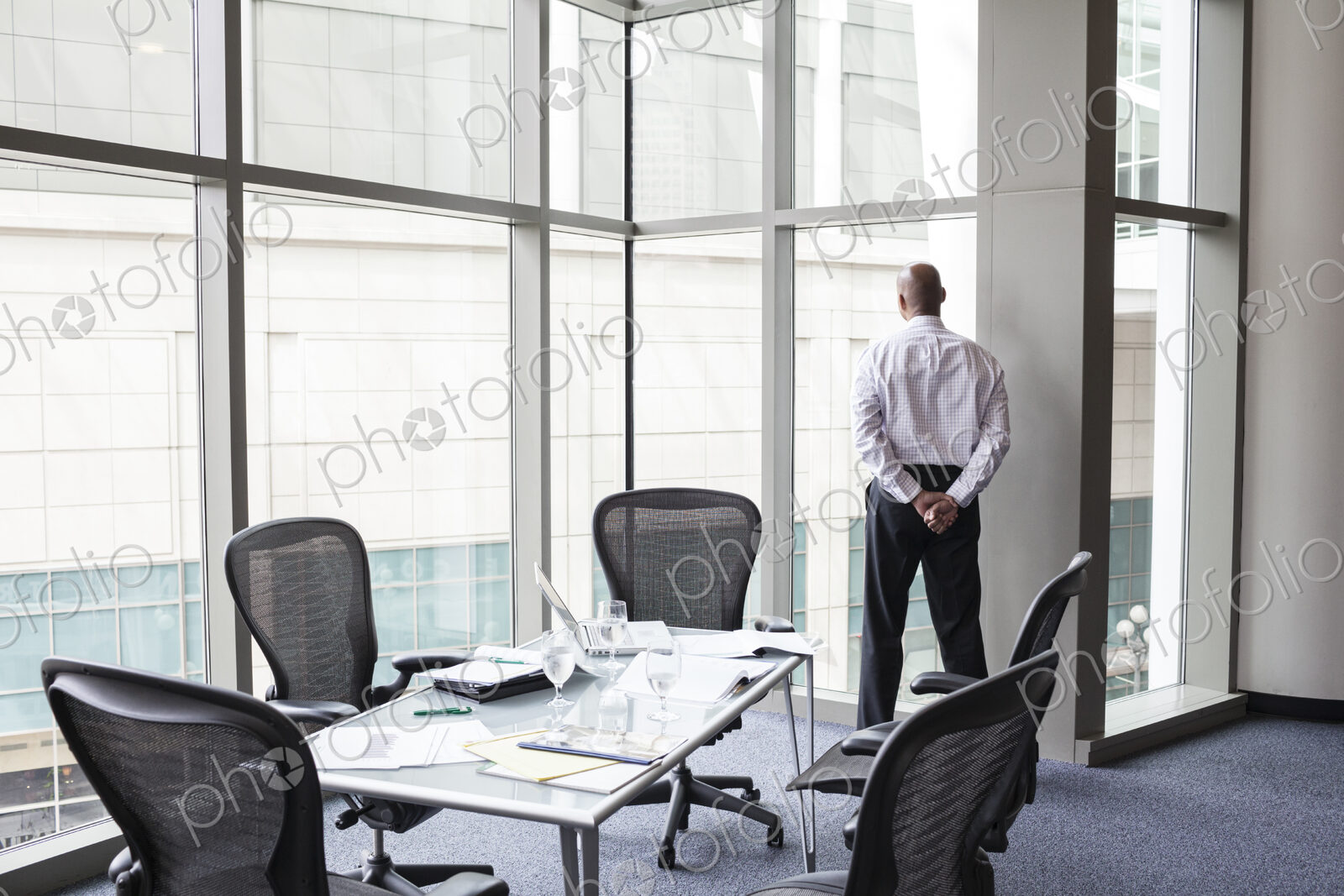 A businessman at a convention center window looking out of the window