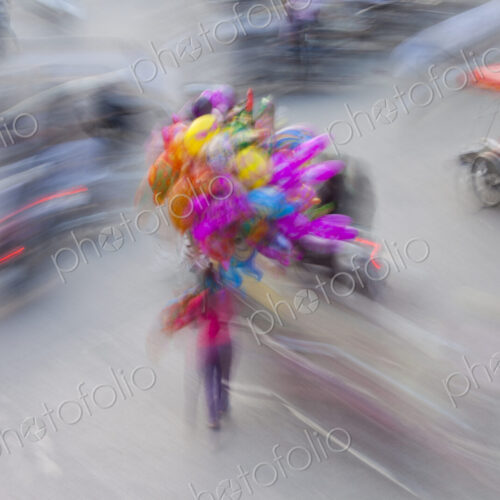 A busy street in Hanoi city, with motorscooter traffic and people with colourful balloons. A busy street in Hanoi city, with motorscooter traffic and people with colourful balloons.