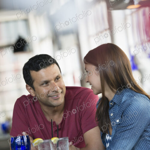A cafe interior. A man and woman seated at a table. A cafe interior. A man and woman seated at a table.