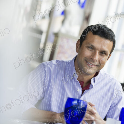 A cafe interior. A man seated at a table. A cafe interior. A man seated at a table.