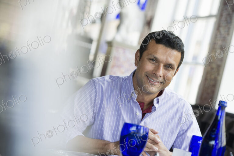 A cafe interior. A man seated at a table.