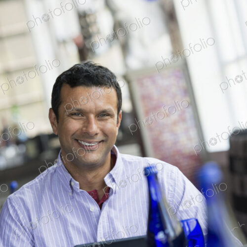 A cafe interior. A man sitting using a digital tablet.