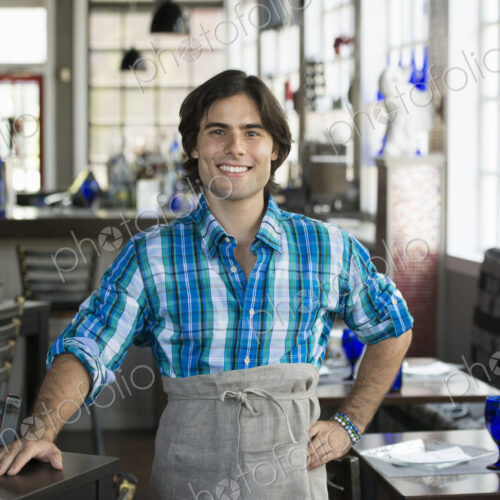 A cafe interior. A waiter in a checked shirt. A cafe interior. A waiter in a checked shirt.