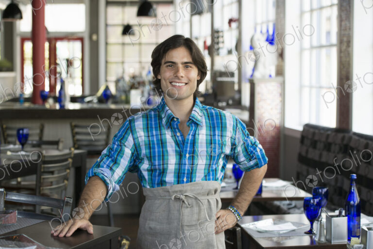 A cafe interior. A waiter in a checked shirt.