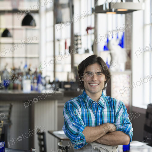 A cafe interior. A waiter in a checked shirt. A cafe interior. A waiter in a checked shirt.