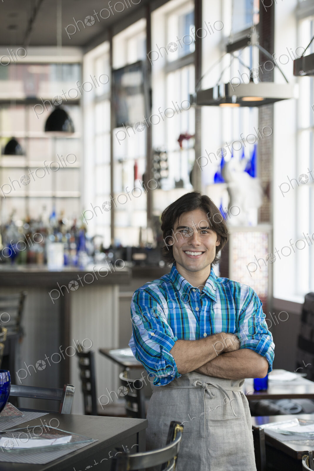 A cafe interior. A waiter in a checked shirt.