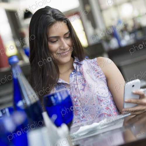 A cafe interior. A woman using a smart phone. A cafe interior. A woman using a smart phone.