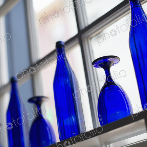 A cafe interior. Bright blue glassware on empty tables. A cafe interior. Bright blue glassware on empty tables.