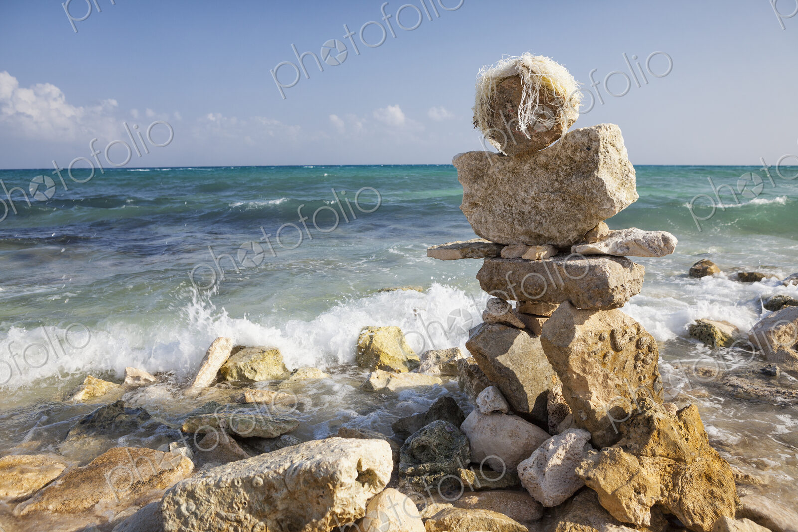 A cairn, pile of stones on the beach at the water’s edge