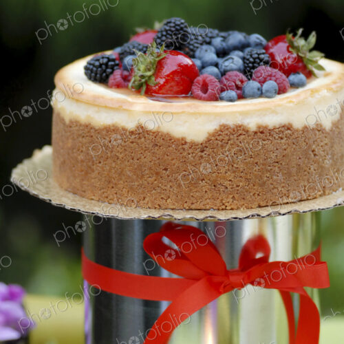A cake with icing and fresh berries and a red ribbon. A cake with icing and fresh berries and a red ribbon.