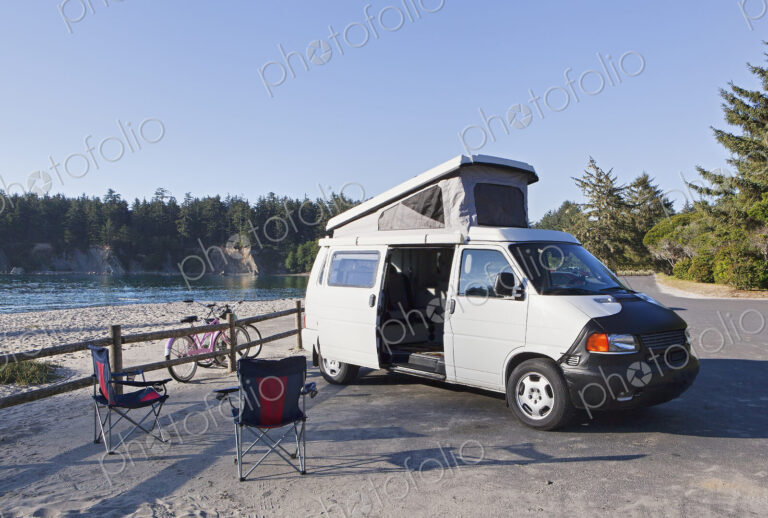 A camper van parked in a cove on Cape Arago on the Oregon coast., camping chairs and…