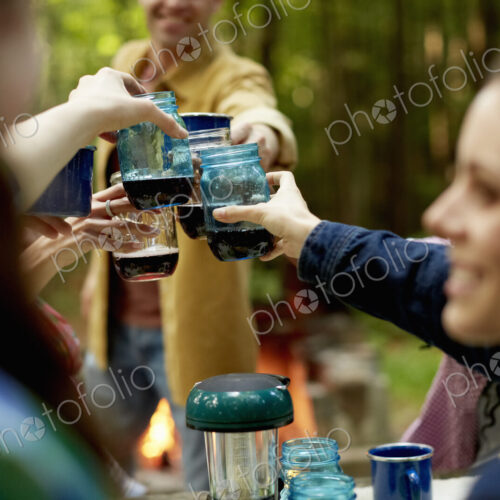 A campsite clearing in the woods. People seated around a table.