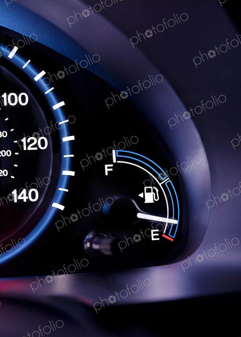 A car interior, the dashboard,instrument panel,and fuel gauge. A speedometer