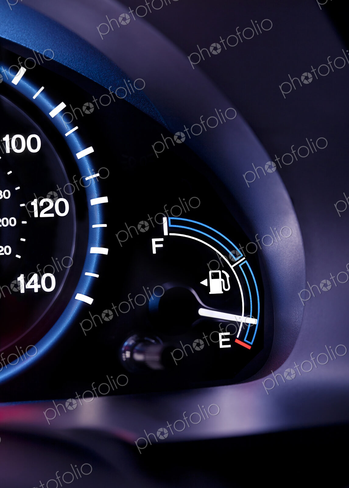 A car interior, the dashboard,instrument panel,and fuel gauge. A speedometer