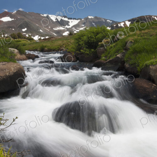 A cascade of fast flowing white water over rocks in a valley in the mountains. A cascade of fast flowing white water over rocks in a valley in the mountains.