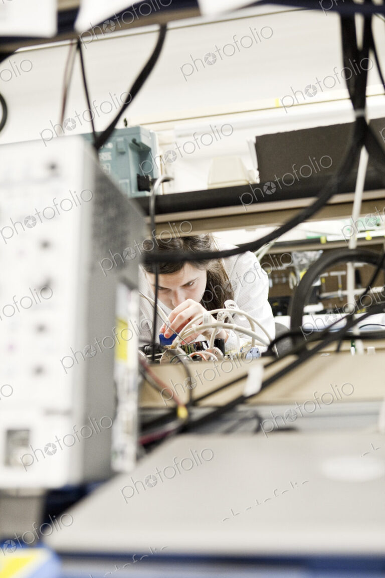 A caucaasian female techinician working over a problem in a technical research and…