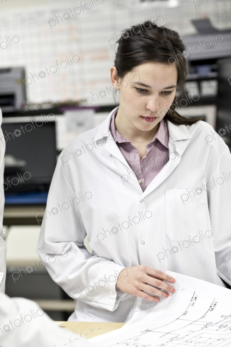 A caucaasian female techinician working over a problem in a technical research and…