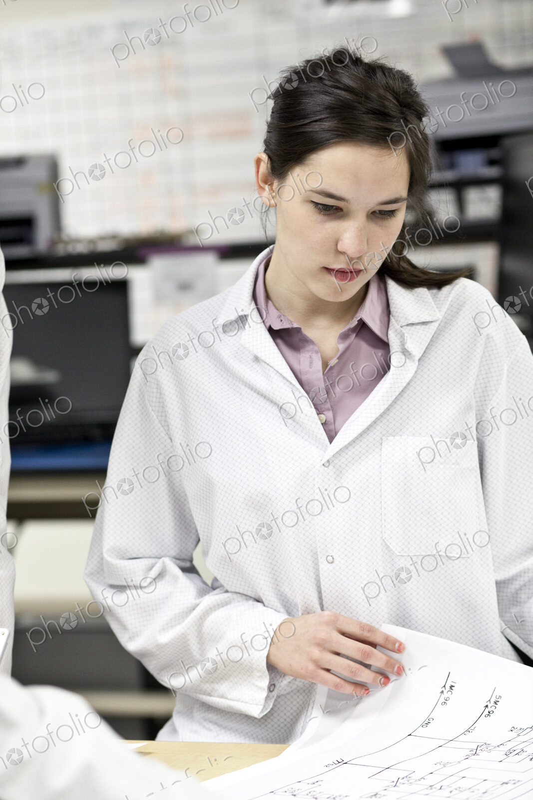 A caucaasian female techinician working over a problem in a technical research and…