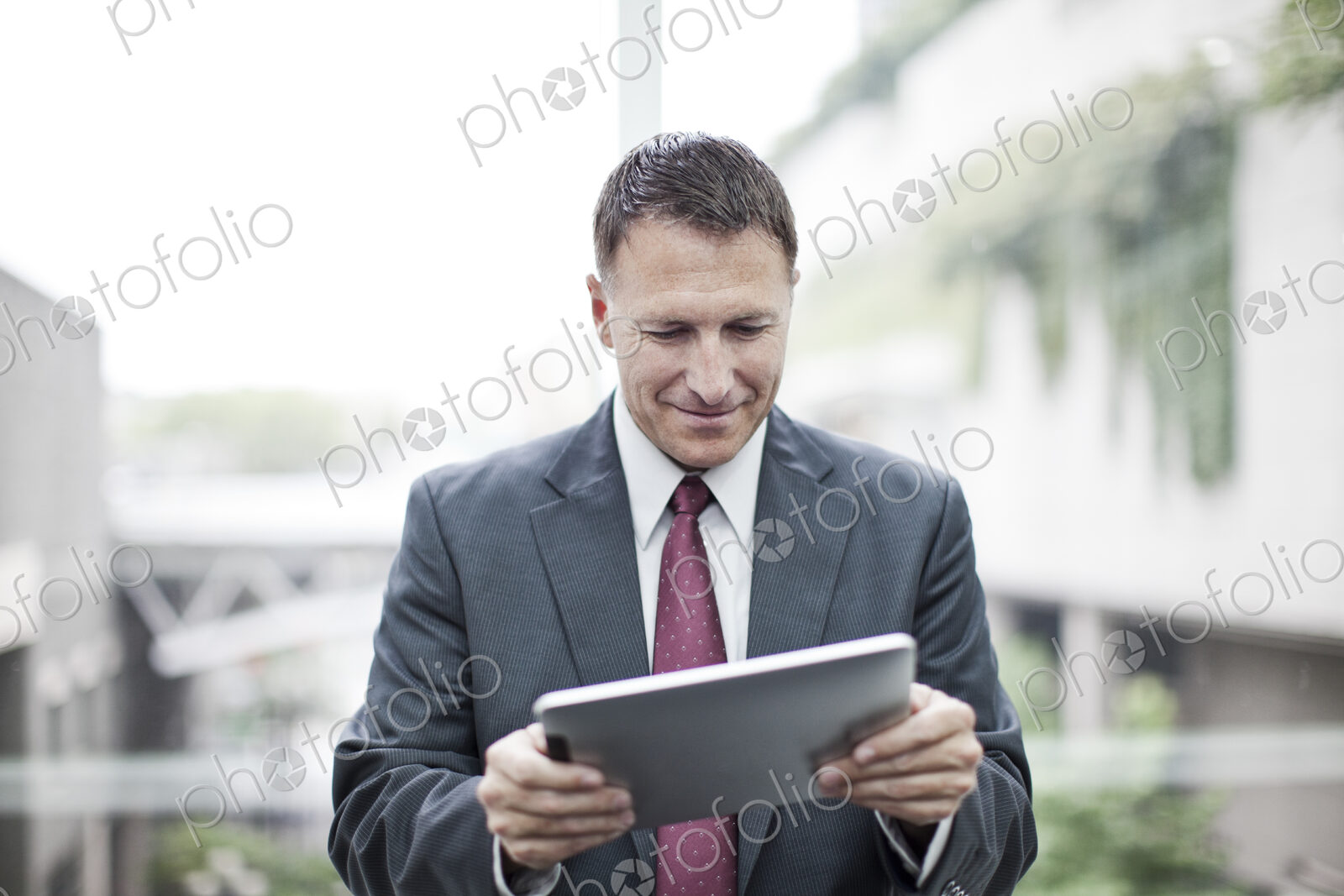 A caucasian businessman checking his notebook computer while standing in a convention…