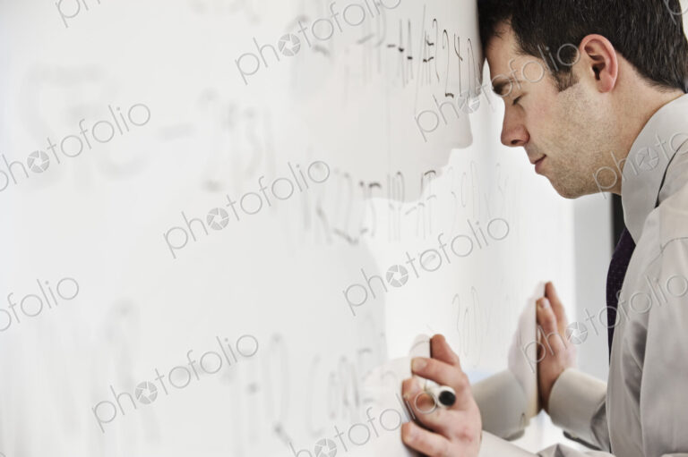 A caucasian businessman under stress from over working.