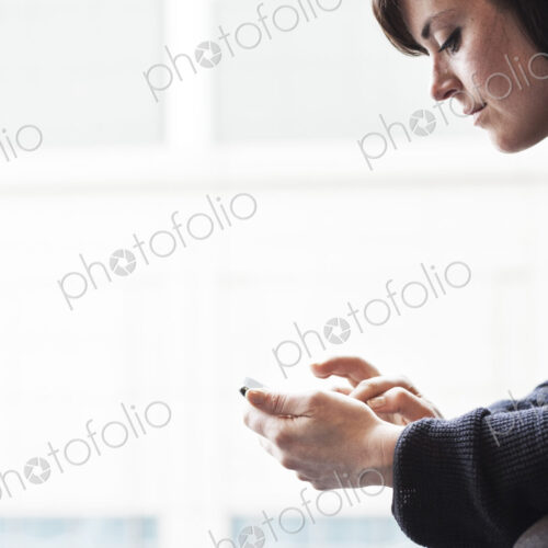 A caucasian businesswoman working on a cell phone. A caucasian businesswoman working on a cell phone.
