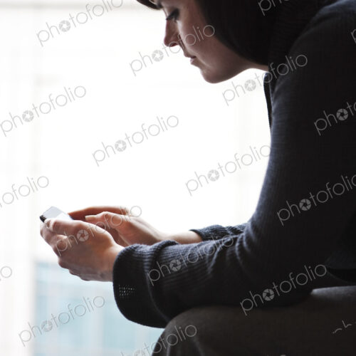 A caucasian businesswoman working on a cell phone. A caucasian businesswoman working on a cell phone.