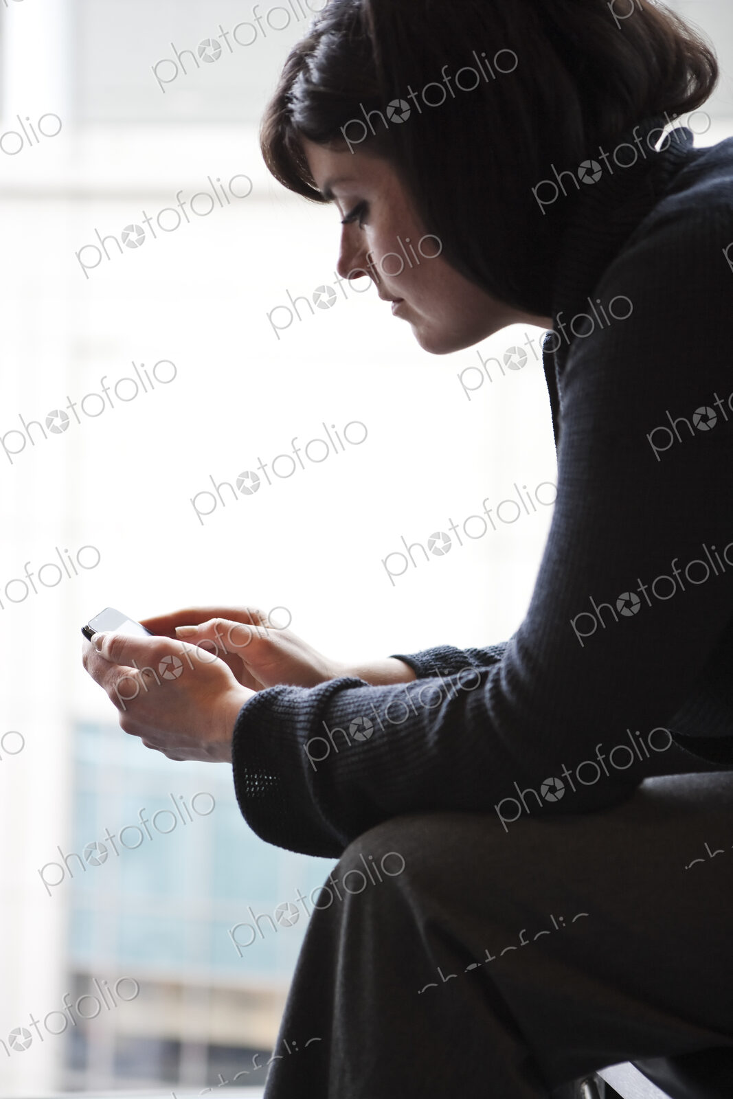 A caucasian businesswoman working on a cell phone.